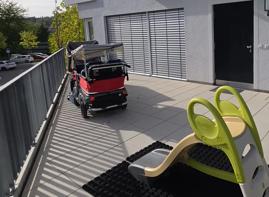 Roter E-Turtle-Kinderbus auf der Terrasse